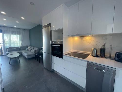 uma cozinha com armários brancos e uma sala de estar em New built 3-bed penthouse with pool, Mar de Plata em Mazarrón