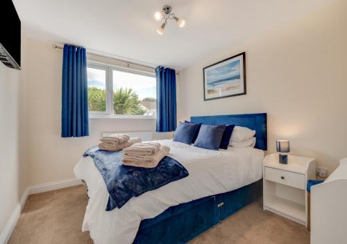 a bedroom with a large bed with blue curtains at Avondale in Crackington Haven