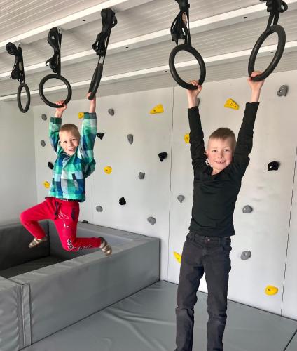 two young children playing on a climbing gym at Zeltāres in Jelgava
