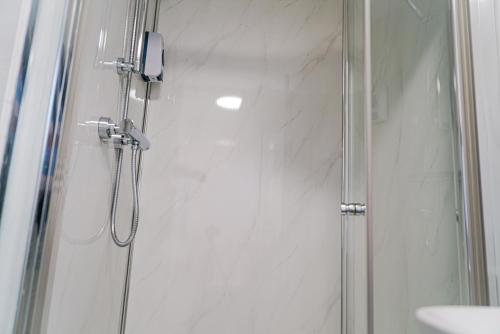 a shower with a glass door next to a sink at Centra Studios in London