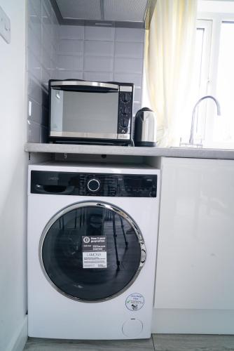 a microwave sitting on top of a washing machine in a kitchen at Centra Studios in London