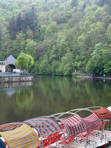 a group of chairs and umbrellas on a river at B&B ArdennesT in Bouillon