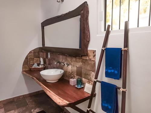 a bathroom with a sink and a mirror on a table at Zamunda Garden View in Tulum