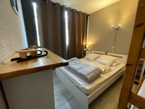 een slaapkamer met een bed en een houten tafel bij Appart 2 Étoiles 6-8 pers Piau Engaly L Ours Résidence Moudang II Pied pistes in Aragnouet