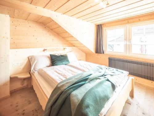 um quarto com uma cama num quarto de madeira em Dorfplatz Urnäsch em Urnäsch
