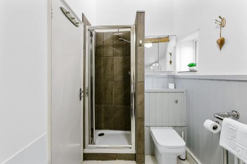 uma casa de banho com um chuveiro e um WC. em Bay Cottage, Brixham em Brixham