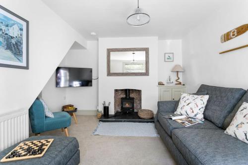 a living room with a couch and a fireplace at Bay Cottage, Brixham in Brixham
