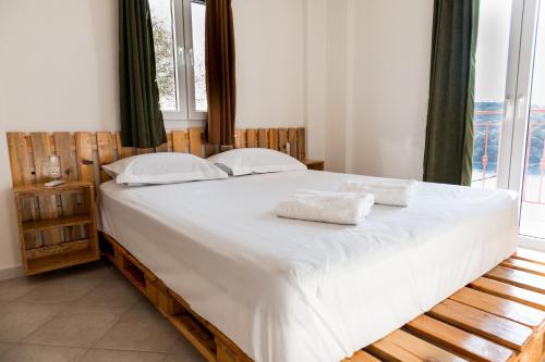 a bedroom with a large bed with white sheets and pillows at Home Sweet Home Unique Sea View in Sivota