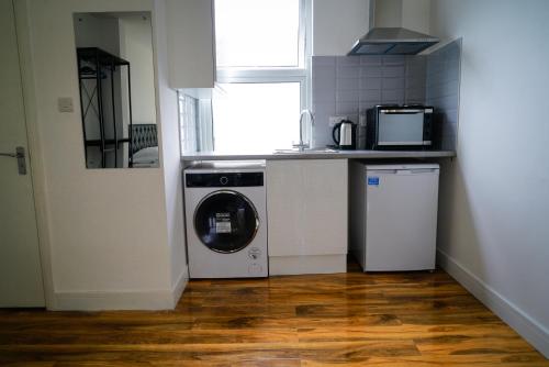 a kitchen with a washing machine and a window at Centra Studios in London