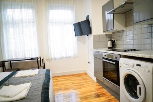 a kitchen with a washer and dryer in a room at Centra Studios in London