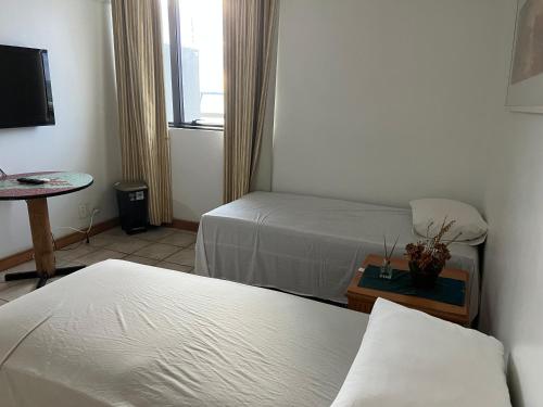 Postel nebo postele na pokoji v ubytování Apartamento no tropical executive hotel com varanda, 1 cama de casal e 2 camas de solteiro