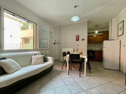 a living room with a couch and a table and a refrigerator at La tua Vacanza al Mare in Borghetto Santo Spirito