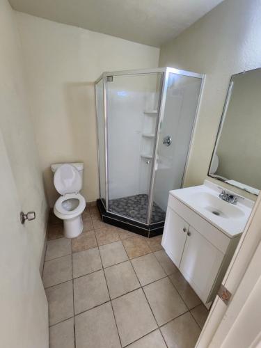 uma casa de banho com um chuveiro, um WC e um lavatório. em HomeTown Inn and Suites em Mesquite