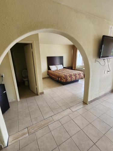 a bedroom with a bed and an archway with a television at HomeTown Inn and Suites in Mesquite