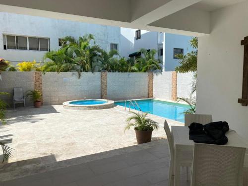 a patio with a swimming pool and a table and chairs at Apartamento Juan Dolio in Juan Dolio