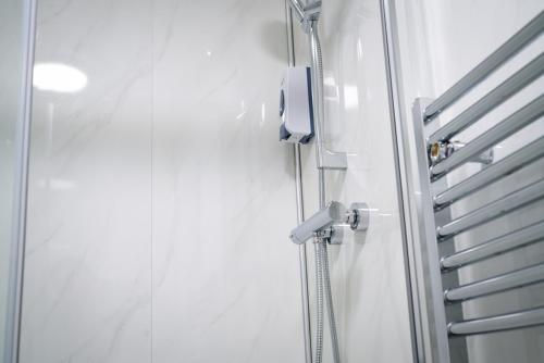 um chuveiro numa casa de banho com uma porta de vidro em Centra Studios em Londres
