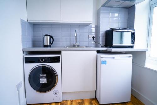 a kitchen with a washing machine and a sink at Centra Studios in London