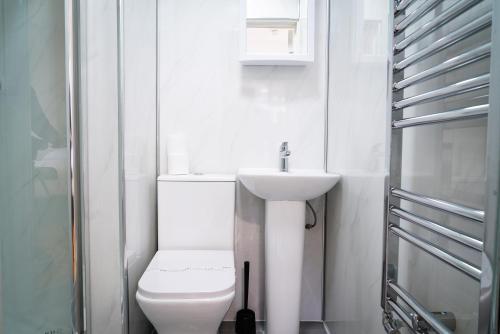 a white bathroom with a toilet and a sink at Centra Studios in London
