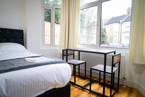 1 dormitorio con cama, mesa y ventana en Centra Studios en Londres