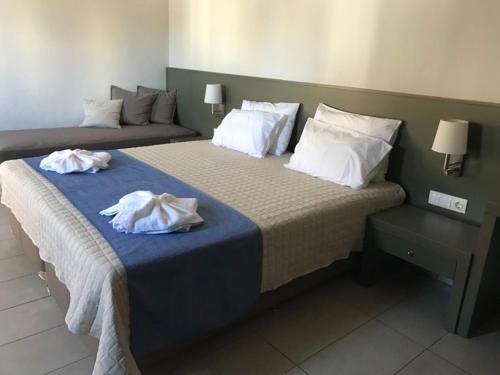 a hotel room with two beds with towels on them at Ledra Maleme Hotel in Maleme