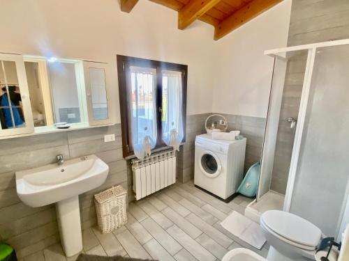ein Badezimmer mit einer Waschmaschine, einer Waschmaschine und einem Trockner in der Unterkunft In Love 01 in Montichiari