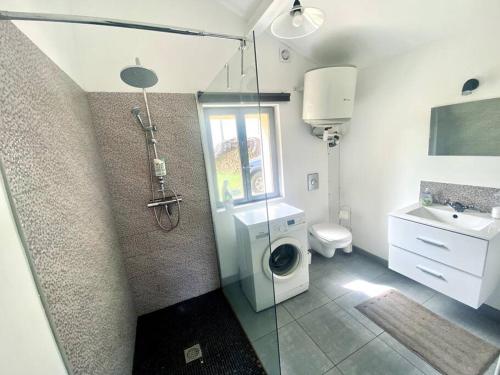 une salle de bain avec douche et machine à laver dans l'établissement La Lande - Petite maison avec jardin, à Vendat