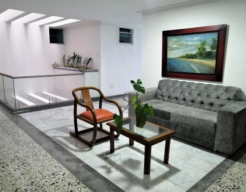 een woonkamer met een bank en een stoel bij Hotel Panorama in Sincelejo