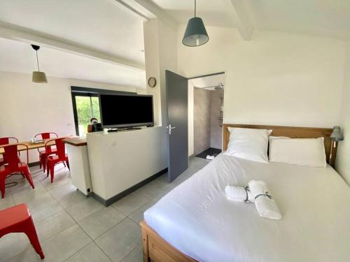 - une chambre avec un grand lit blanc et une salle à manger dans l'établissement La Lande - Petite maison avec jardin, à Vendat