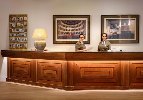 two women sitting at a reception desk at Evora Hotel in Évora