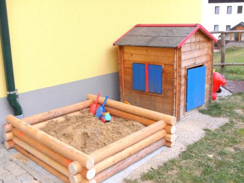 a wooden sandbox with a small play house at Landgasthof Sepplwirt in Kindberg