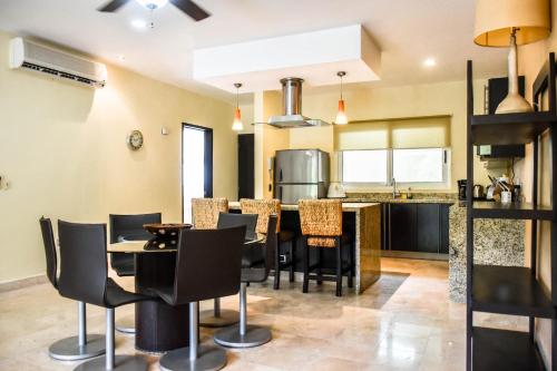 a kitchen and dining room with a table and chairs at Mamitas Village by Casago in Playa del Carmen
