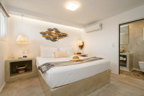 a white bedroom with a bed and a bathroom at Santo Concept Luxury Villas in Agia Anna Naxos