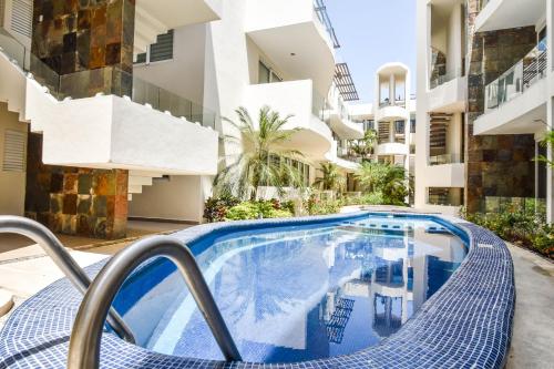a swimming pool in front of a building at Mamitas Village by Casago in Playa del Carmen