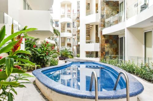 an apartment with a swimming pool in the middle of a building at Mamitas Village by Casago in Playa del Carmen