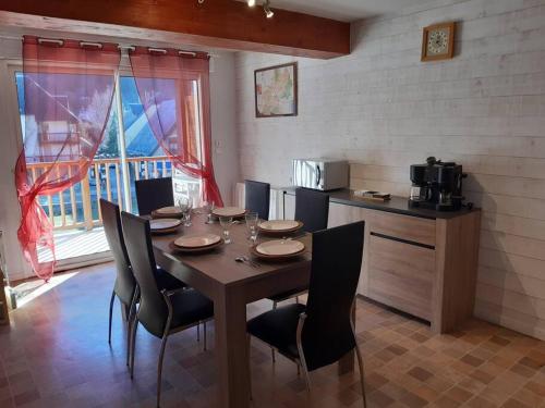 uma sala de jantar com mesa e cadeiras e uma cozinha em Appartement duplex classé 4 étoiles plein centre village em Saint-Lary-Soulan