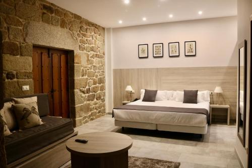 - une chambre avec un lit king-size et un canapé dans l'établissement Hotel A Torre do Xudeu, à Tui