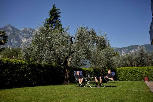 リーヴァ・デル・ガルダにあるAppartamenti Sant'Alessandroの草の中に座る二人