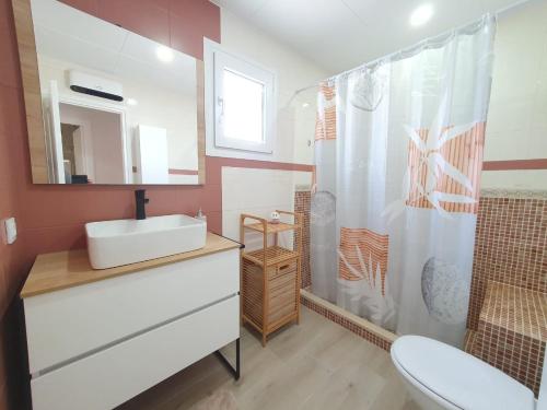 een badkamer met een witte wastafel en een douche bij Chalet Marinera Riumar Pura Natura in Riumar