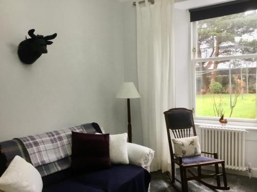a living room with a couch and a chair and a window at Chapelhill Hideaway Isle of Bute licence AR00654F in Rothesay
