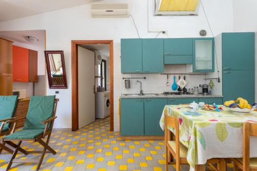 a kitchen with blue cabinets and a table and chairs at La Veranda in Torre Grande