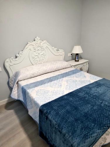 Un dormitorio con una cama con una manta azul. en Casa Alcabre (Samil), en Vigo