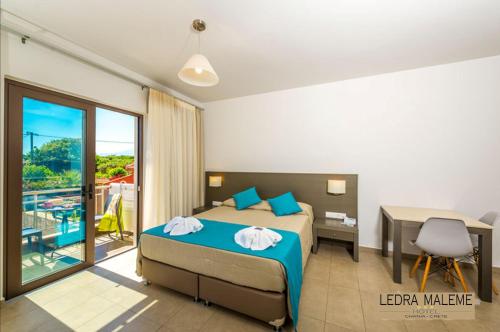Ledra Maleme Hotel في ماليم: غرفة نوم بسرير ومكتب ونافذة