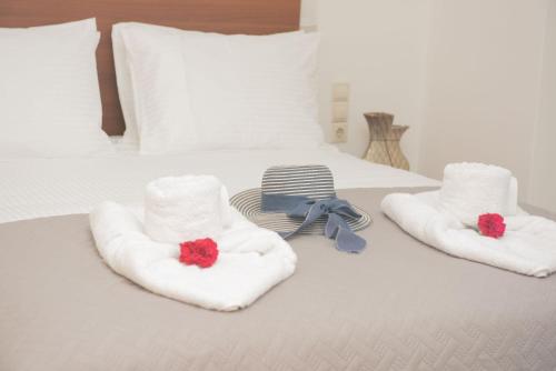 a bed with towels and a pair of red flowers at House Angelina in Galiá