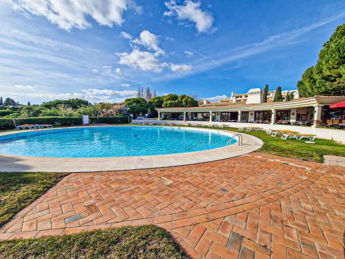 a large swimming pool on a brick patio at Encosta da Praia in Lagoa