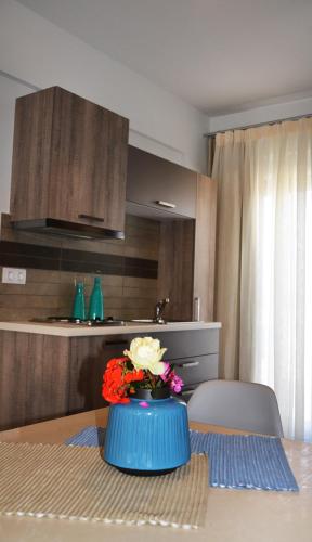 a blue vase with flowers on a table in a kitchen at Ledra Maleme Hotel in Maleme