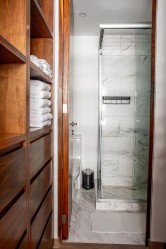 a bathroom with a shower with a glass door at Japandi style apartment in Polanco in Mexico City