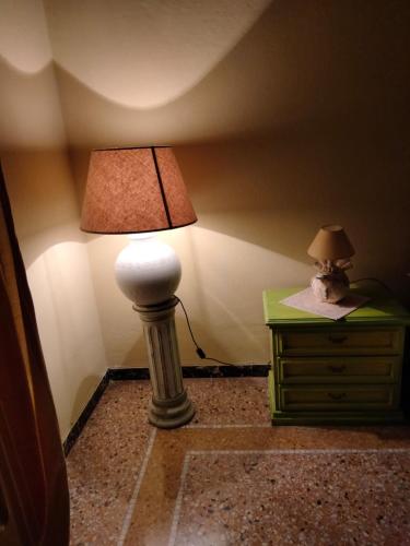 a lamp on a dresser with a stuffed animal on top of it at Bed and Breakfast Su Niu in Quartucciu