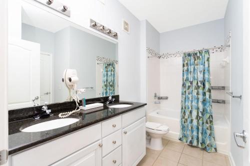 a bathroom with two sinks and a toilet at COZY Condo - Perfect Location Close to Disney in Kissimmee