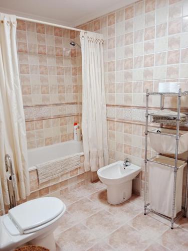 a bathroom with a toilet and a tub and a sink at El Mirador 2 in Viveiro