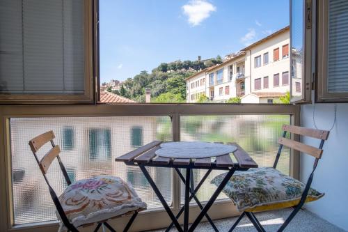 una mesa y dos sillas frente a una ventana en B&B Il Rosmarino, en Cortona